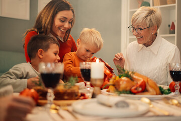 Family celebrating christmas opening gifts at dinner table