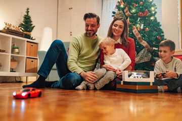 Family playing with remote controlled car on christmas morning © Zamrznuti tonovi