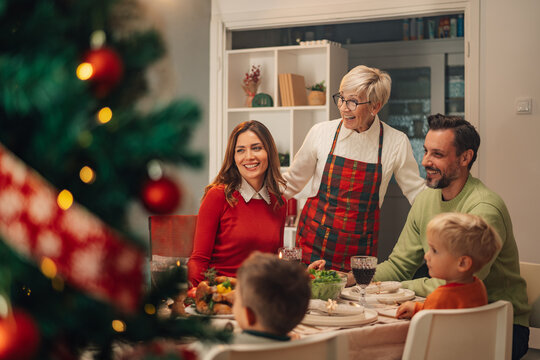 Happy family enjoying christmas dinner at home - Powered by Adobe