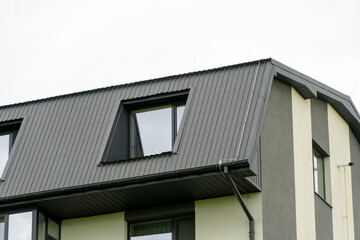 Modern architectural design of a residential building roof with unique angles and window details
