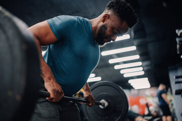 Determined bodybuilder lifting weights in modern gym