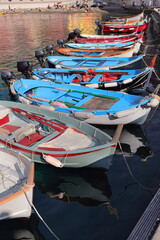 Vernazza town, sunbathers enjoy the last sun on the small beach inside the port facing the dock...