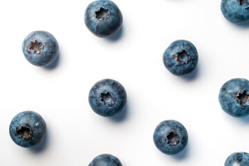 A visually appealing, clean top-down shot of fresh, plump blueberries scattered on a white surface, perfect for use in health food packaging, recipe blogs, or promotional materials for grocery stores.