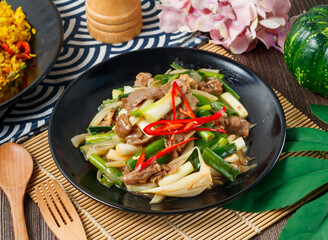 Scallion Beef stir fry with fresh spring onions and red chili in bowl side view of hong kong food