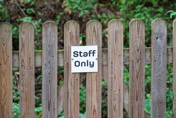 A weathered wooden fence stands as a barrier, marked with a 