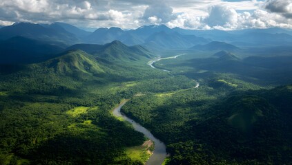 Fototapeta premium Majestic aerial view of a winding river through lush green mountains under dramatic sunlight and clouds