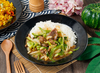 stir fried beef with green bell peppers and onions, served over white rice in bowl side view of hong kong food