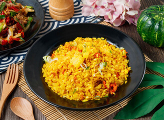 Fried Rice with chunks of pineapple, chili, and scallions in a black bowl side view of hong kong food