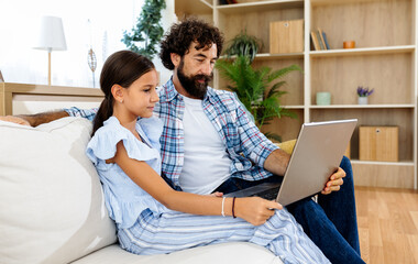 Father and daughter working together on laptop