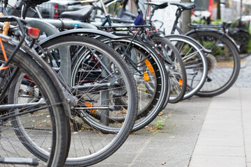 Obraz premium Bicycles parked in line near a sidewalk in a residential neighborhood.