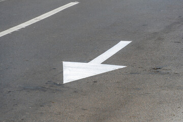 Road marking indicating left turn on asphalt in urban area during daytime