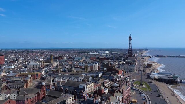 aerial drone view of North Blackpool showing the town and coast with Blackpool tower and all three piers on a cloudy day