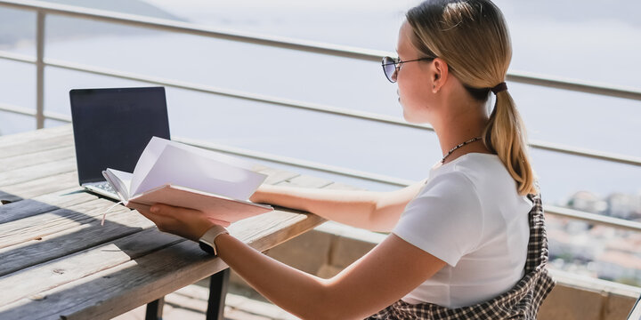 digital nomad woman working remotely from a cozy kitchen during breakfast. Remote work, sustainability, wellness, Gen Z, conscious living, home office and online freelancing - Powered by Adobe