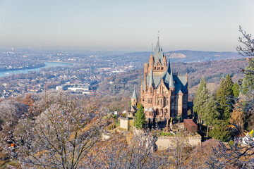 Winterliche Aussicht vom Drachenfels auf die Drachenburg und das Rheintal, im Hintergrund die Silhouette von Bonn