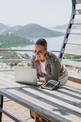 digital nomad woman working remotely from a cozy kitchen during breakfast. Remote work,...