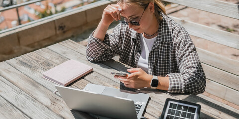 digital nomad woman working remotely from a cozy kitchen during breakfast. Remote work, sustainability, wellness, Gen Z, conscious living, home office and online freelancing