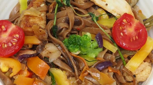 Schezwan Noodles or Vegetable Hakka Noodles or Chow Mein in white bowl. Schezwan Noodles is indo-chinese cuisine hot dish with udon noodles, vegetables and chilli sauce with meat, Japanese food