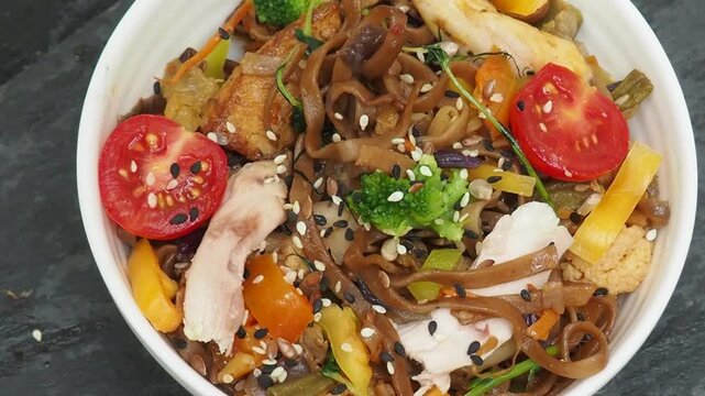 Schezwan Noodles or Vegetable Hakka Noodles or Chow Mein in white bowl. Schezwan Noodles is indo chinese cuisine hot dish with udon noodles, vegetables and chilli sauce with meat, Japanese food