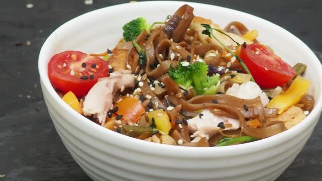 Schezwan Noodles or Vegetable Hakka Noodles or Chow Mein in white bowl. Schezwan Noodles is indo chinese cuisine hot dish with udon noodles, vegetables and chilli sauce with meat, Japanese food