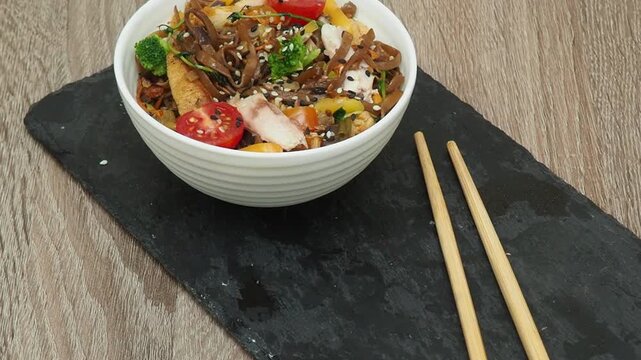 Schezwan Noodles or Vegetable Hakka Noodles or Chow Mein in white bowl. Schezwan Noodles is indo chinese cuisine hot dish with udon noodles, vegetables and chilli sauce with meat, Japanese food