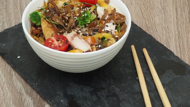 Schezwan Noodles or Vegetable Hakka Noodles or Chow Mein in white bowl. Schezwan Noodles is indo chinese cuisine hot dish with udon noodles, vegetables and chilli sauce with meat, Japanese food