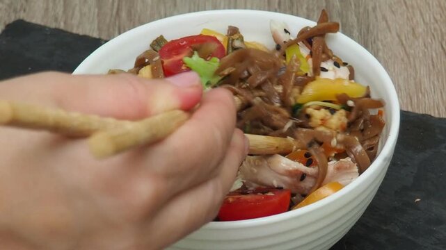 Schezwan Noodles or Vegetable Hakka Noodles or Chow Mein in white bowl. Schezwan Noodles is indo chinese cuisine hot dish with udon noodles, vegetables and chilli sauce with meat, Japanese food