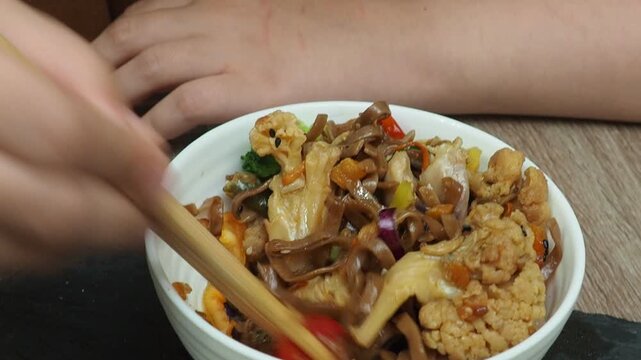 Schezwan Noodles or Vegetable Hakka Noodles or Chow Mein in white bowl. Schezwan Noodles is indo-chinese cuisine hot dish with udon noodles, vegetables and chilli sauce with meat, Japanese food