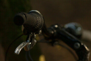 A detailed close-up view of a bicycle handlebar featuring a textured grip and a shiny brake lever, showcasing the mechanics of cycling gear.