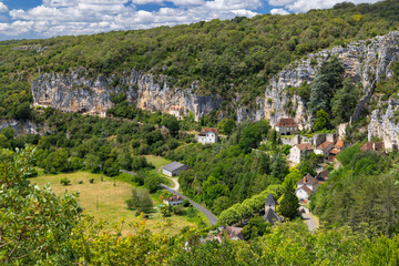 Saint Sulpice nestled in the valley of the Lot, France, showing cliffs and lush vegetation
