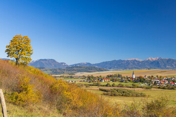 Obraz premium Liptovske Sliace village surrounded by colorful autumn foliage and mountains in Slovakia