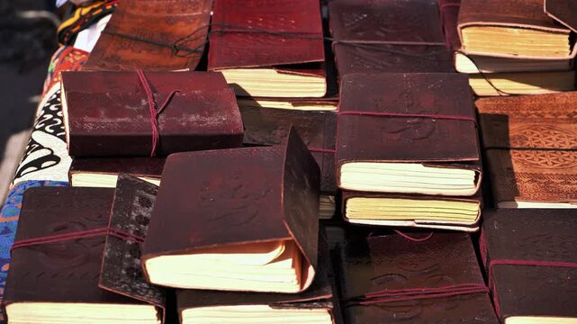 Leather religious Indian books on a street shop table in India.