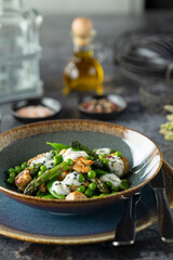 Delicious chicken salad with green peas, asparagus and yogurt sauce garnished with sesame seeds