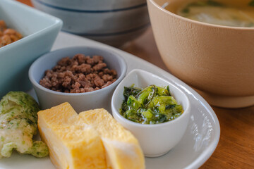 Traditional Japanese breakfast with rice, miso soup, natto, and side dishes
