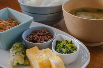 Traditional Japanese breakfast with rice, miso soup, natto, and side dishes
