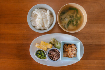 Traditional Japanese breakfast with rice, miso soup, natto, and side dishes
