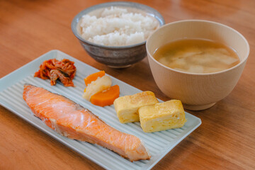 Traditional Japanese breakfast with grilled salmon, tamagoyaki, rice, and miso soup
