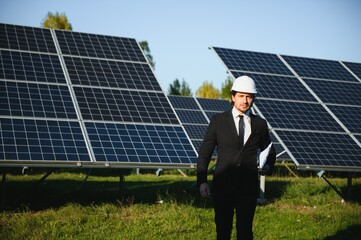 Portrait of a successful businessman or engineer inspecting the operation of solar panels. The...