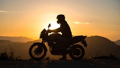 Silhouette of a motorcyclist at sunset over a mountain range
