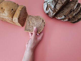 Design holding a slice of bread on a pastel pink background