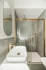 Luxurious bathroom with a porcelain sink on a marble countertop, high-end gold faucets, and a...