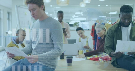 Six professionals collaborating around wooden table in office, with design sheets, fabric swatches