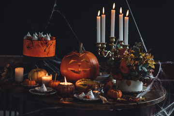 Homemade delicious chocolate cake with coloured orange cream and meringue ghosts, pumpkins for...