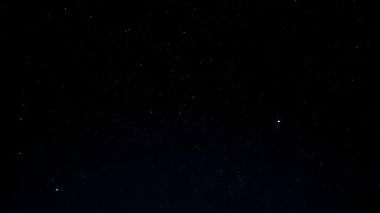 Cielo nocturno con estrellas brillando sobre fondo negro