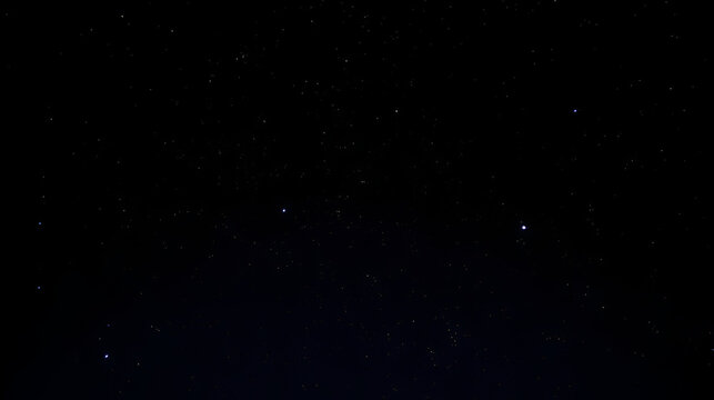 Cielo nocturno con estrellas brillando sobre fondo negro