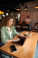 Young woman working on laptop in a cafe