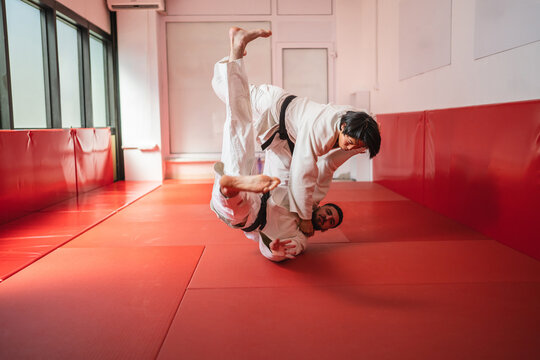 Two judoka athletes training together practicing martial arts throws