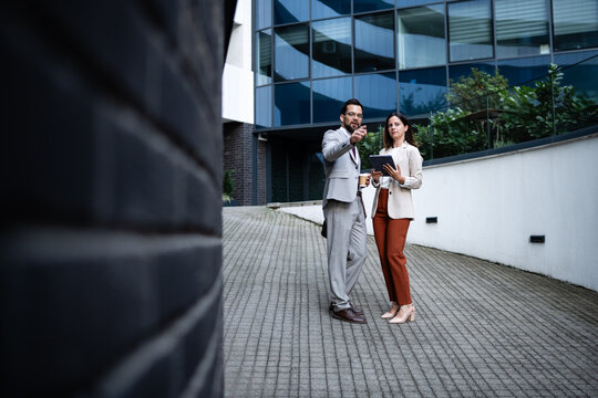Businesspeople discussing a project using digital tablet in urban setting
