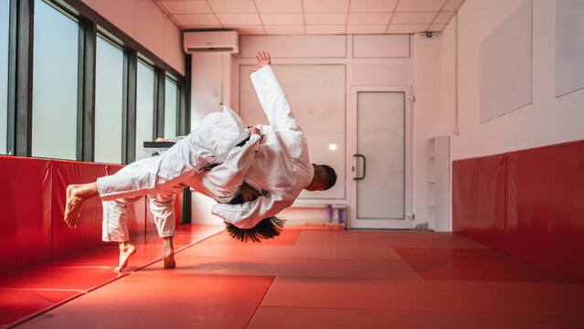 Two judo athletes performing a dramatic throw in training session