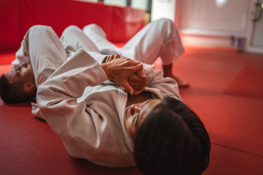 Determined male judo fighter performing a hold on male opponent - Powered by Adobe