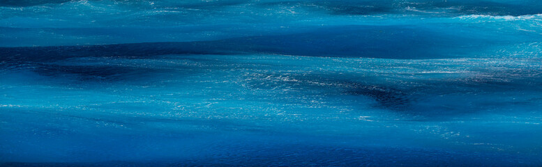 Fototapeta premium Sea surface aerial view. Background shot of clear sea water surface. Blue sea water in calm. Sea texture. Background blue waves of the sea with sea foam. 